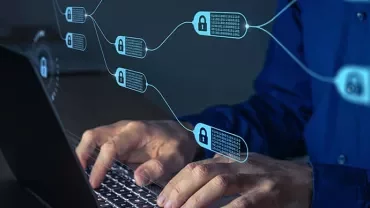 Person typing on a laptop with blockchain nodes shown as a digital overlay.