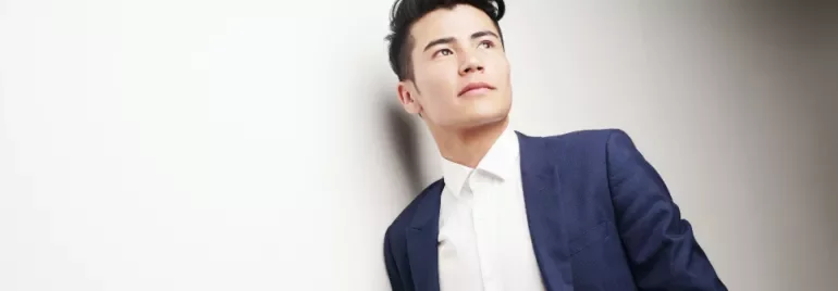 Man in a blue suit and white shirt looking away.