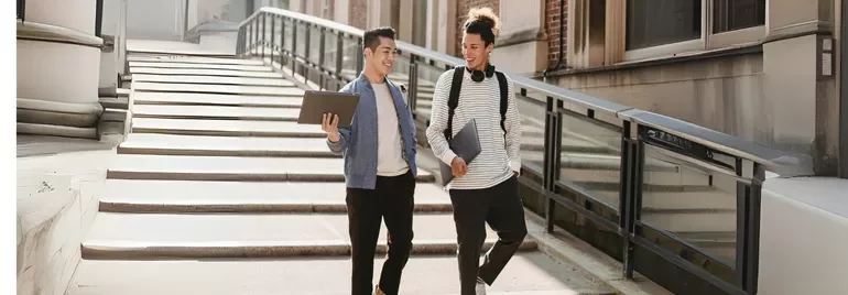 Two fresh graduates walking down the stairs while discussing job interview questions