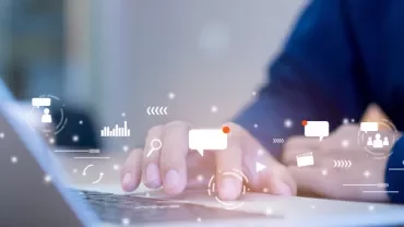 Person using a laptop with digital communication icons overlay.