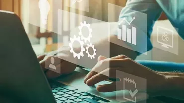 Person typing on laptop with digital icons like graphs and gears overlayed.