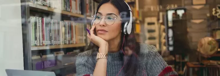 Woman listening to music with headphones in a library