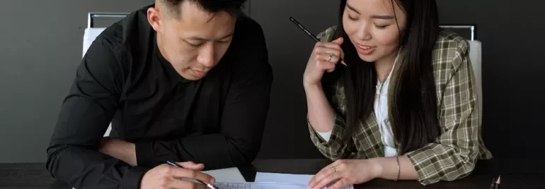 Two people discussing architectural plans at a table.