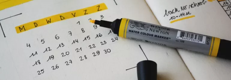Open planner with a yellow marker on a dated calendar page.